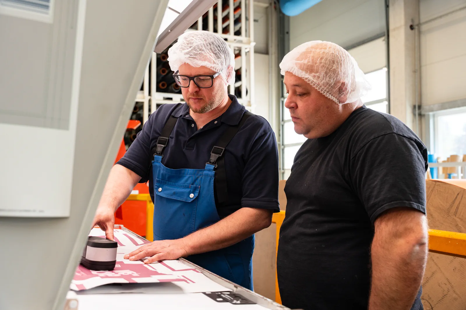 Two Flexopack employees inspecting a freshly printed label sheet